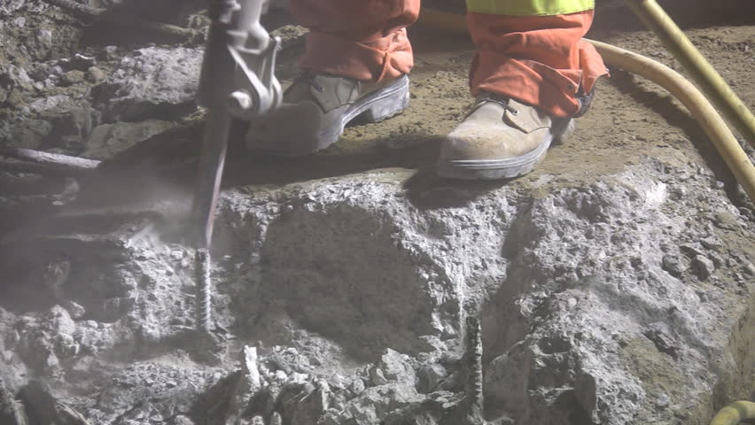 Jackhammer. Good audio. Close-up. Road crew working at night under bright lights.