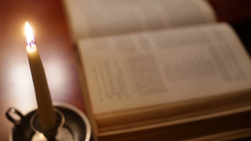 Reading a book, Bible or possibly a magic book.