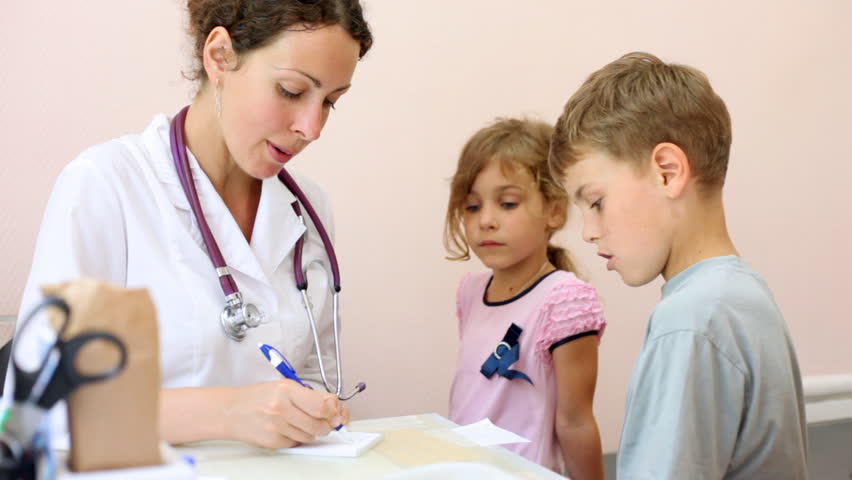woman doctor writes out recipe and puts on it stamp to boy and girl