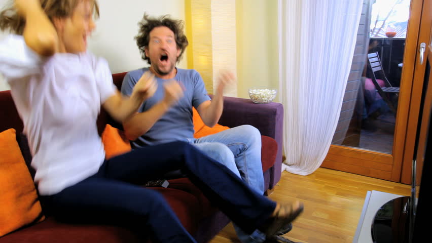 Beautiful woman hugging boyfriend to celebrate happy sport game in tv