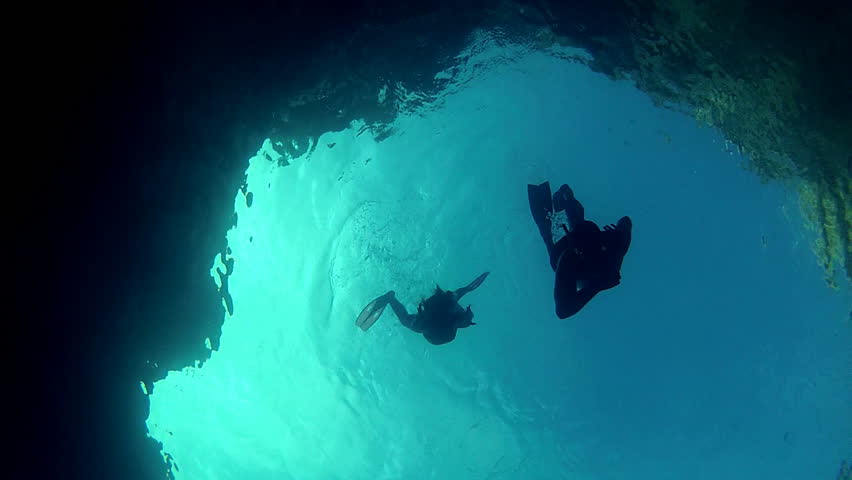Blue diver silhouettes.    
Father and daughter diving. 
