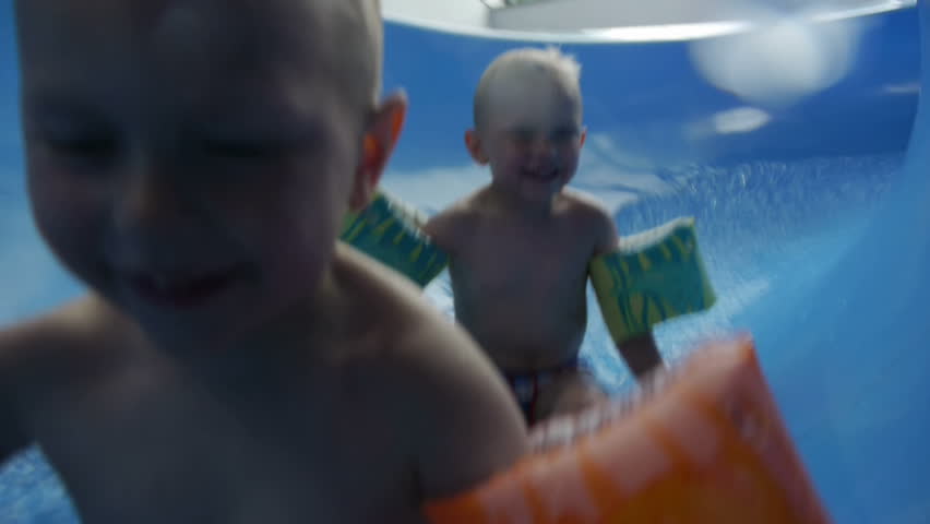 twins go down slide at water park 