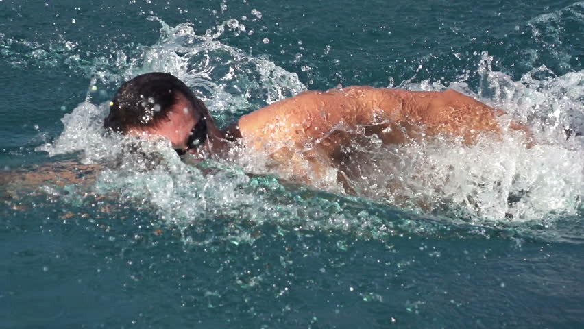 slow motion of professional swimmer swimming the crawl in outdoor pool