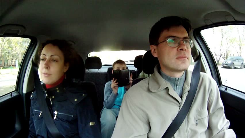 Family from four people goes in car on street of city