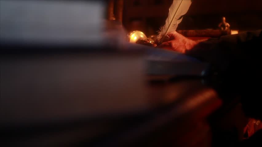 Jib shot of a feather ink pen writing words on an old papyrus paper in a biblical ancient setting.