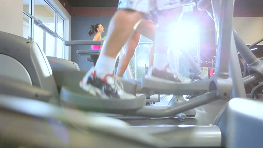 Legs only foreground people exercising on modern equipment in health club