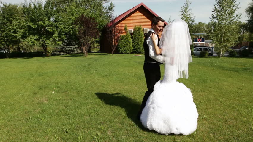 Married couple dancing first wedding dance on the green lawn. Two shots