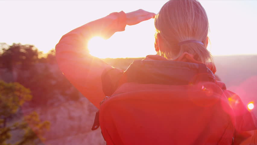 Lone female hiker watching the sun setting over the canyons, USA, Shot on Red Epic
