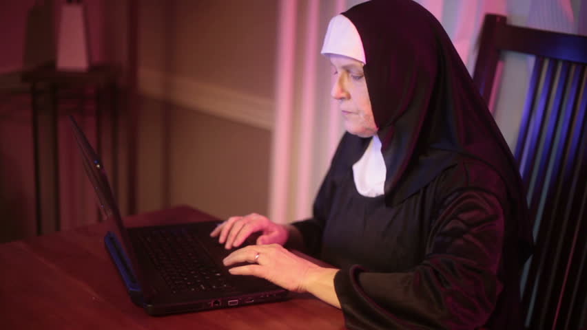 nun typing on the computer