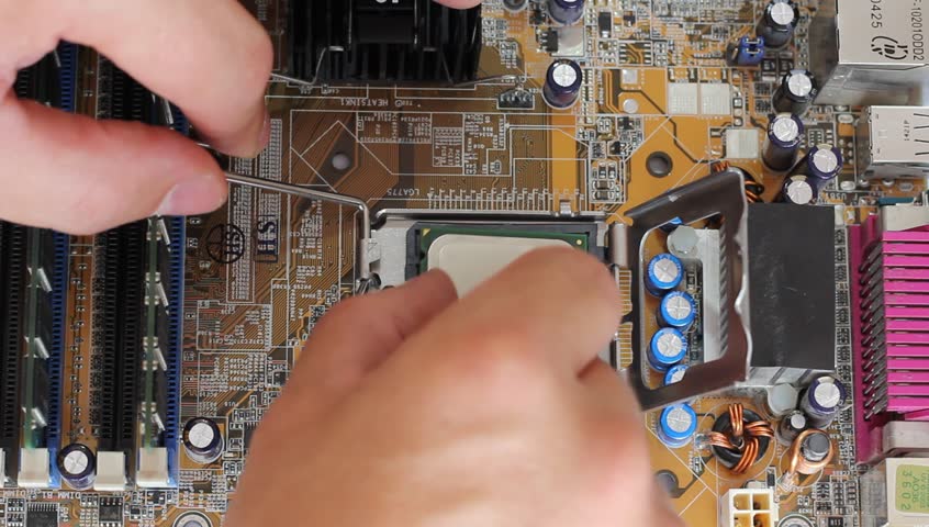 Man pulls out a computer processor from the motherboard. 