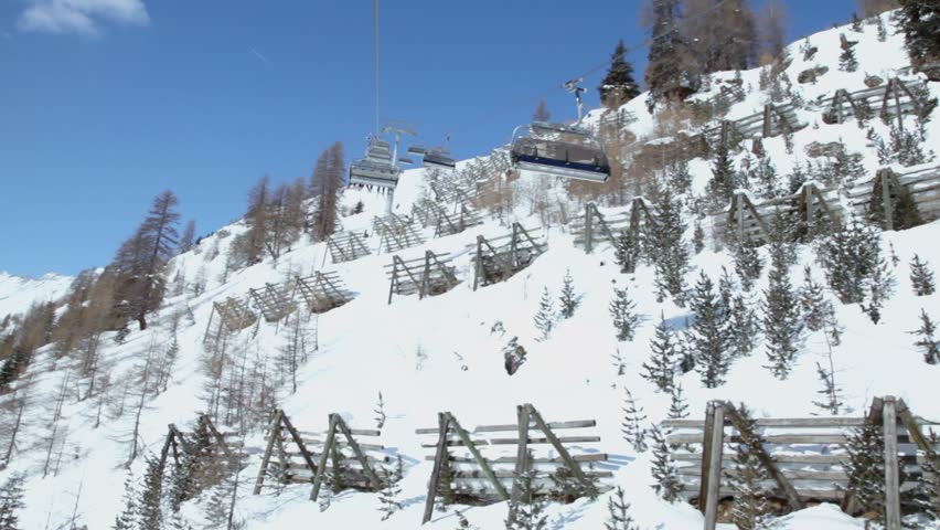 Cableway cabins ride with skiers in snow-capped mountains in Austrian Alps