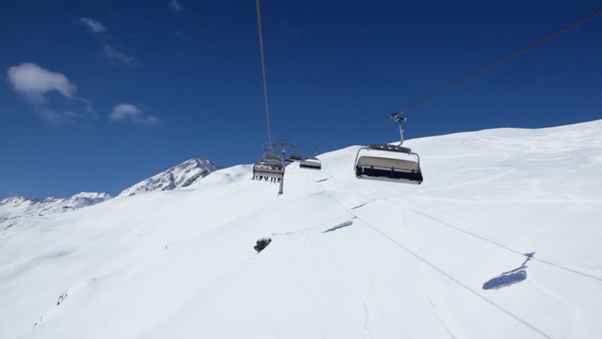 Ropeway cabins ride with skiers in snow-capped mountains in Austrian Alps