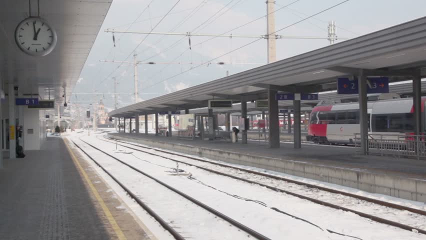 Train ride on railway station at winter day in village near mountains