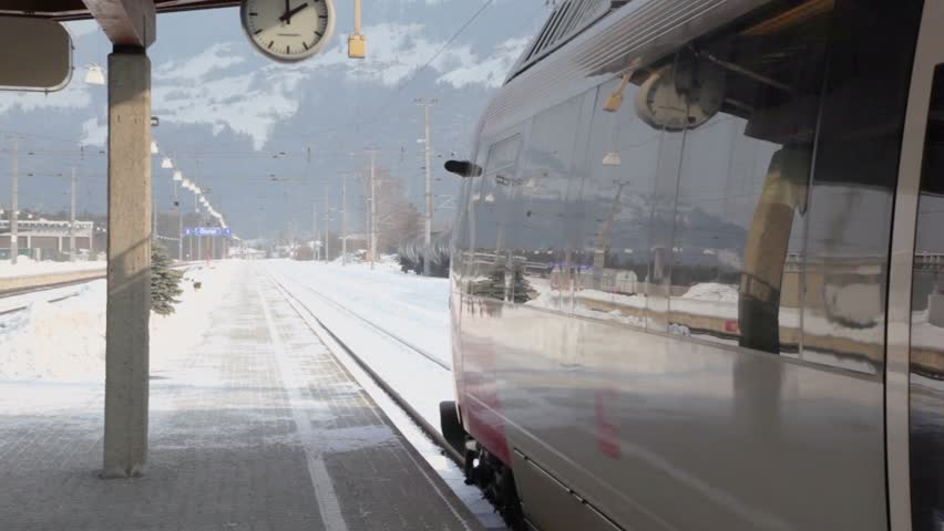 Train stand on railway station at winter day in village near mountains