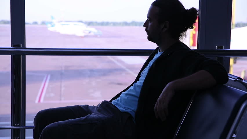 young man waiting his flight in airport lounge