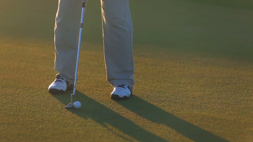Man playing golf at sunset