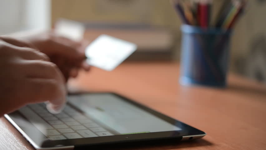 Men using computer for on line purchase with credit card