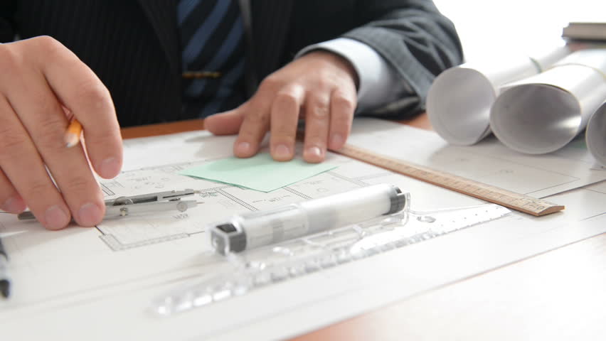 Engineer does measuring on a draft and writes down marks