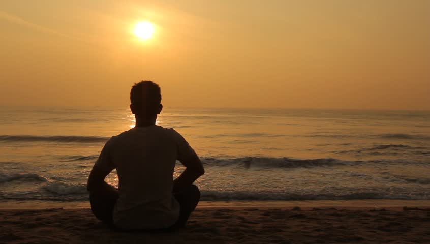 man meditating at sunrise 