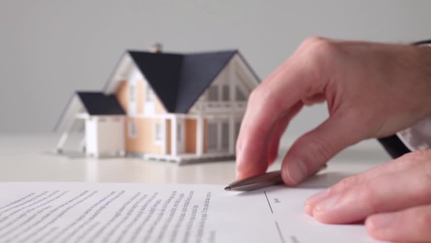 Mortgage contract sign. Model of the house and man confirming mortgage contract.
