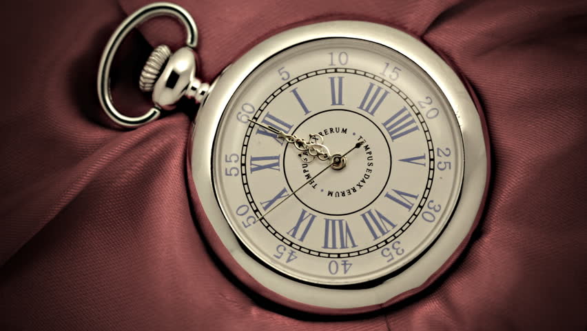 Old silver pocket watch. Vintage clock ticks off seconds marked by ornate hands roman numerals.
