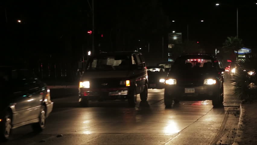 Ambulance breaking through in traffic by night, answering an emergency call