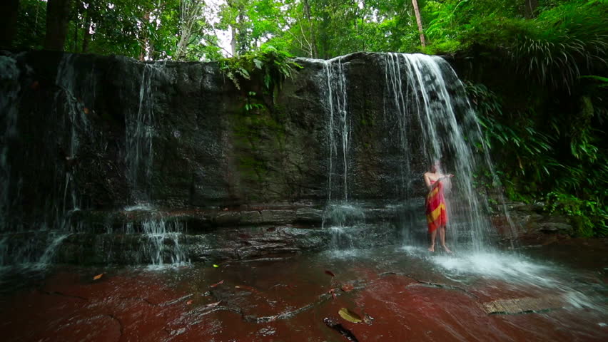 sexy girl with bikini taking a shower in waterfall in the afternoon