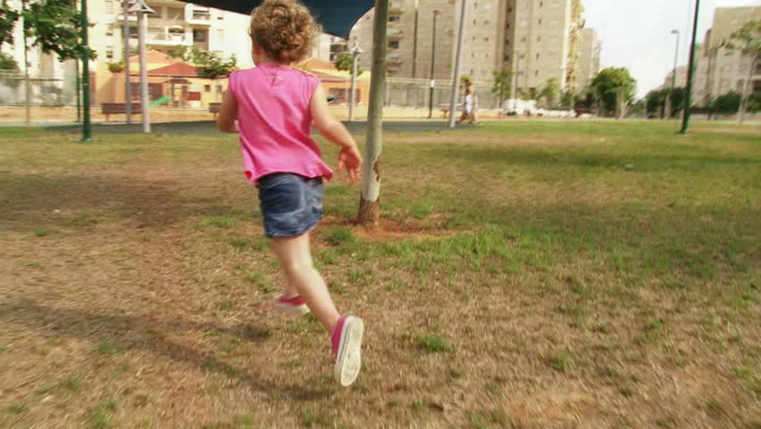Girl running at playground / park in slow motion. Sequence.