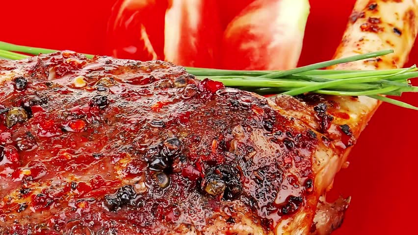savory on red plate: grilled meat shoulder with tomato and chives isolated on white