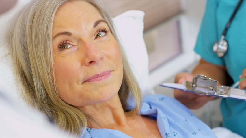 Doctor and Nurse Treating Mature Patient in Hospital