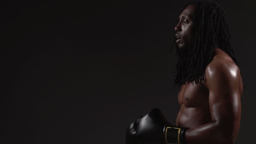 Boxing, African American man boxing, black background