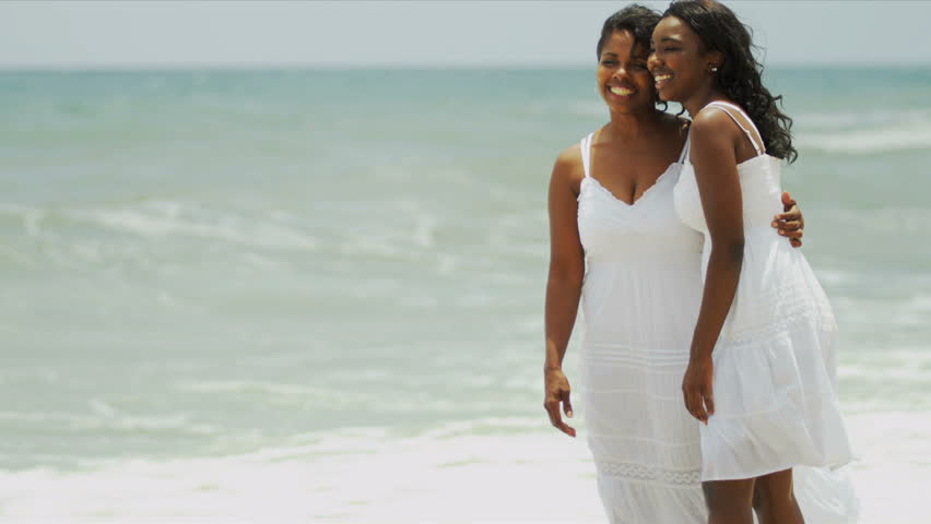 Ethnic daughter walking on beach together loving mother