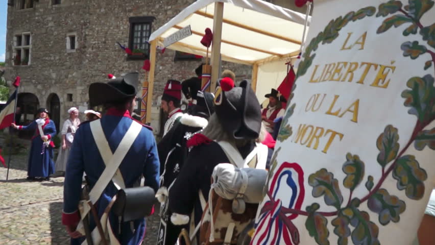 PEROUGES,FRANCE-JULY 14, 2012: Scene of a French Revolution historic commemoration,celebrated every year by many folks wearing common clothes of that time; here some patriots by the recruiters counter