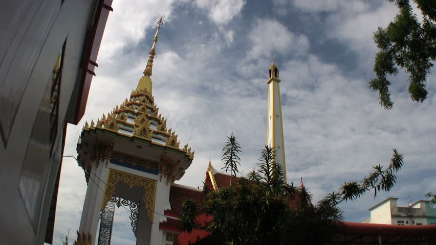 A chimney stack towers over the Buddhist temple before a funeral in rural Thailand.