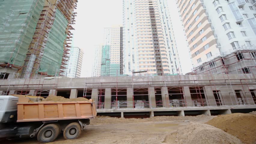 Truck with sand rides backward at construction site of dwelling complex
