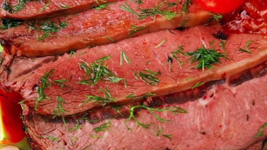 corned beef on plate over wooden table with vegetables and garlic