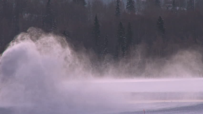 A dynamic shot of clearing the snow off the tarmac in wintertime, early in the morning.