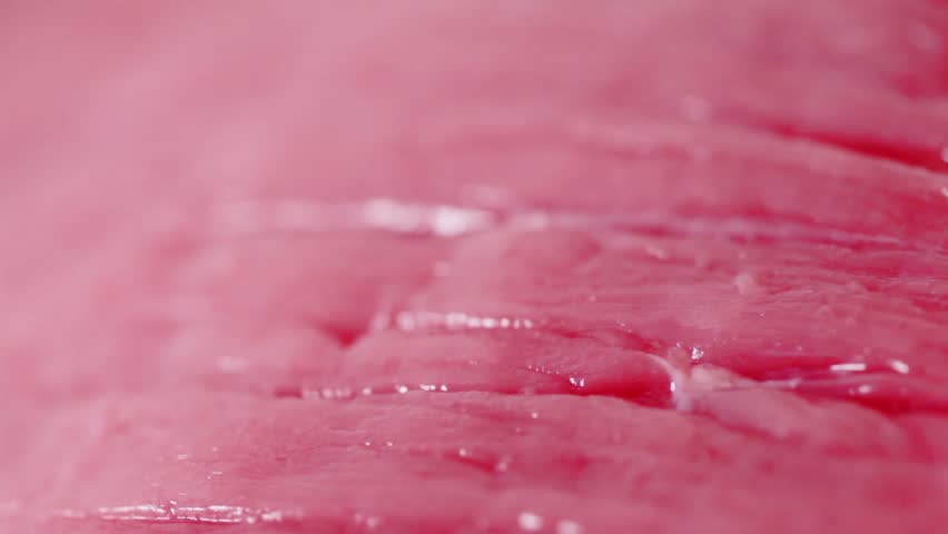 Bit of fresh red uncooked meat flesh circling closeup