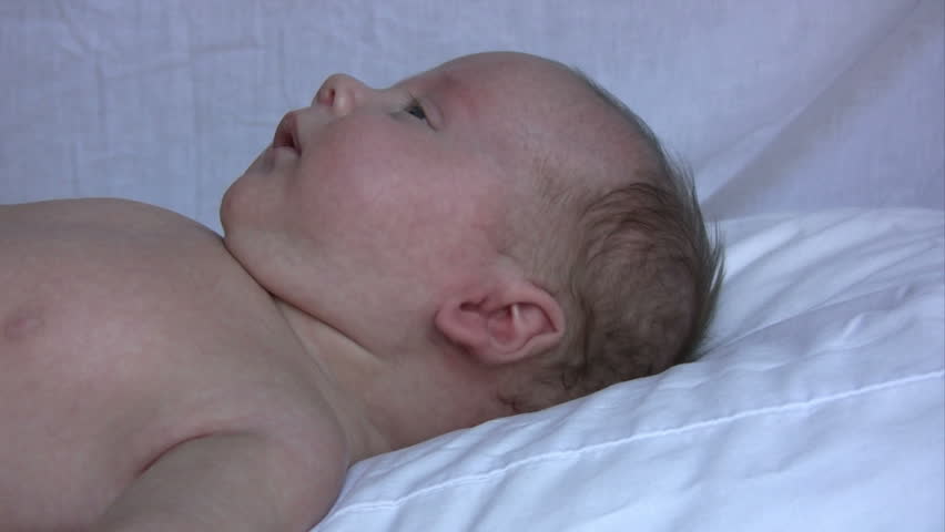 Baby laying down and getting calmed by fathers touch.  HD 1080i