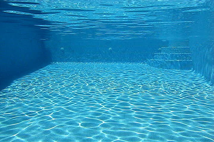 Young man diving into swimming pool