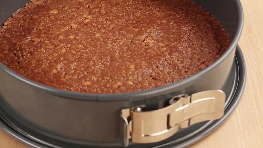 A cream cheese mixture being spread on a biscuit base