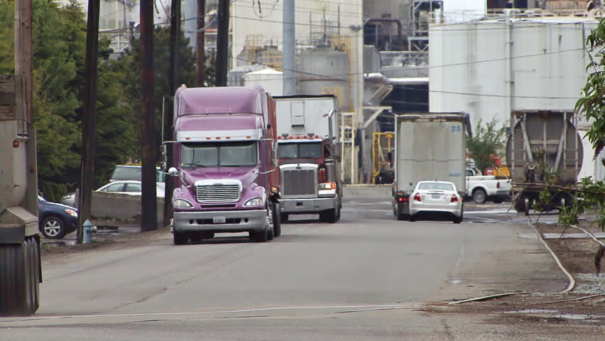TACOMA, WA - CIRCA 2012:Trucks hauling materials and goods out of and through a busy industrial mill complex.