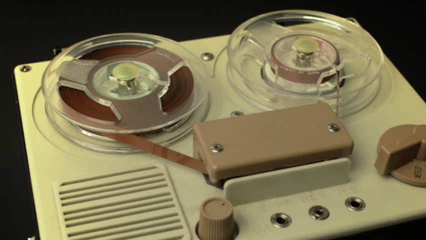 stop-motion of a small vintage reel to reel tape recorder playing from one side to the other