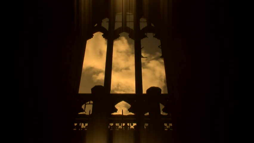 Time lapse clouds through arched church window