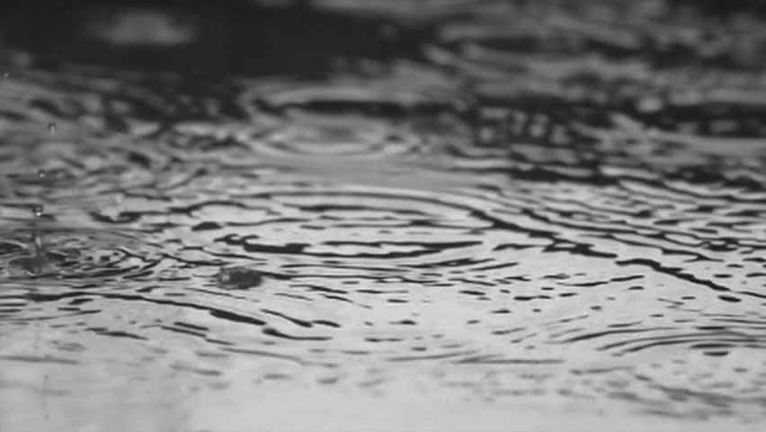 Rain drops dripping in a puddle - slow motion
