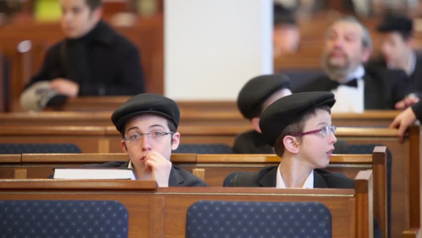 MOSCOW - JAN 27: Jewish boys and other sit on bench in synagogue Beis Menachem at International Holocaust Remembrance Day, on Jan 27, 2012, Moscow, Russia.