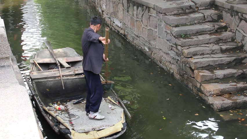 SUZHOU - APRIL 29: Worker cleaning a canal on April 29, 2011, in Suzhou, China. The city is very clean and well preserved and it is famous by its beautiful canals, architecture and gardens.