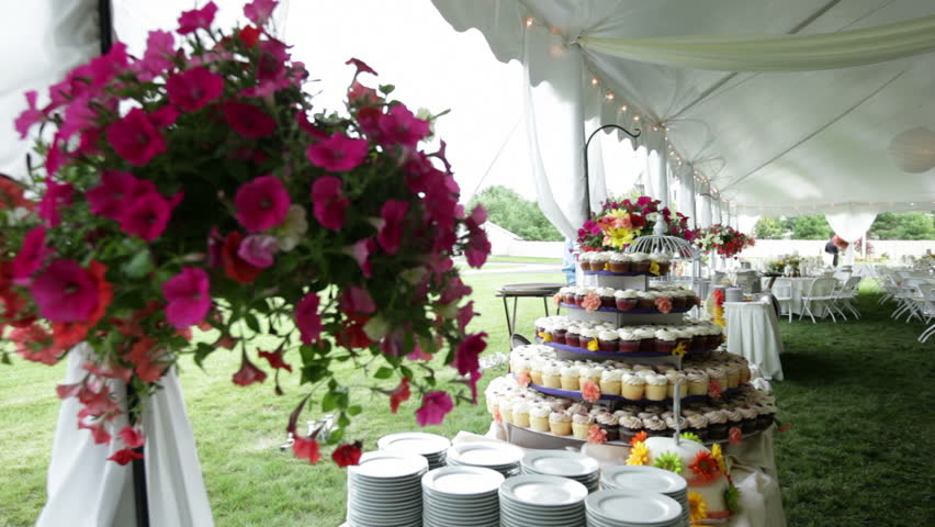 A cupcake cake at a wedding reception with hanging roses