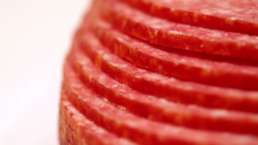 Sliced ??and laid out terraces circles revolve salami sausage on a white background in profile