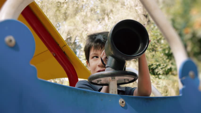 Hispanic Boy Playing with Toy Spyglass at Public Park.